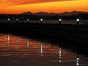 Dock at Yarrow Bay -- houses beginning to light up beneath the shadow of the Olympic Mountains on Lake Washington